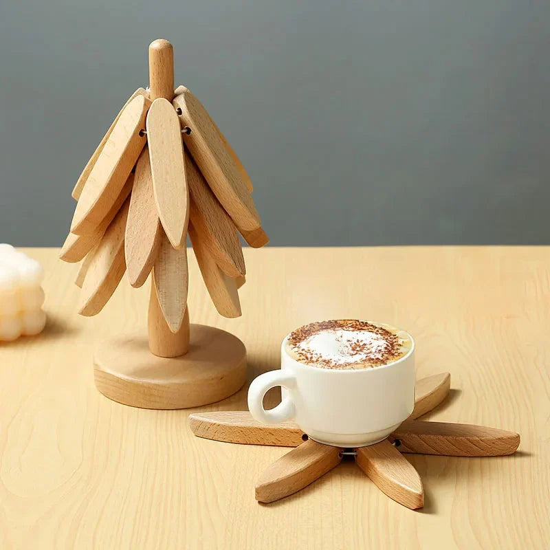Cappuccino sur un dessous de plat en bois clair, à côté du sapin
