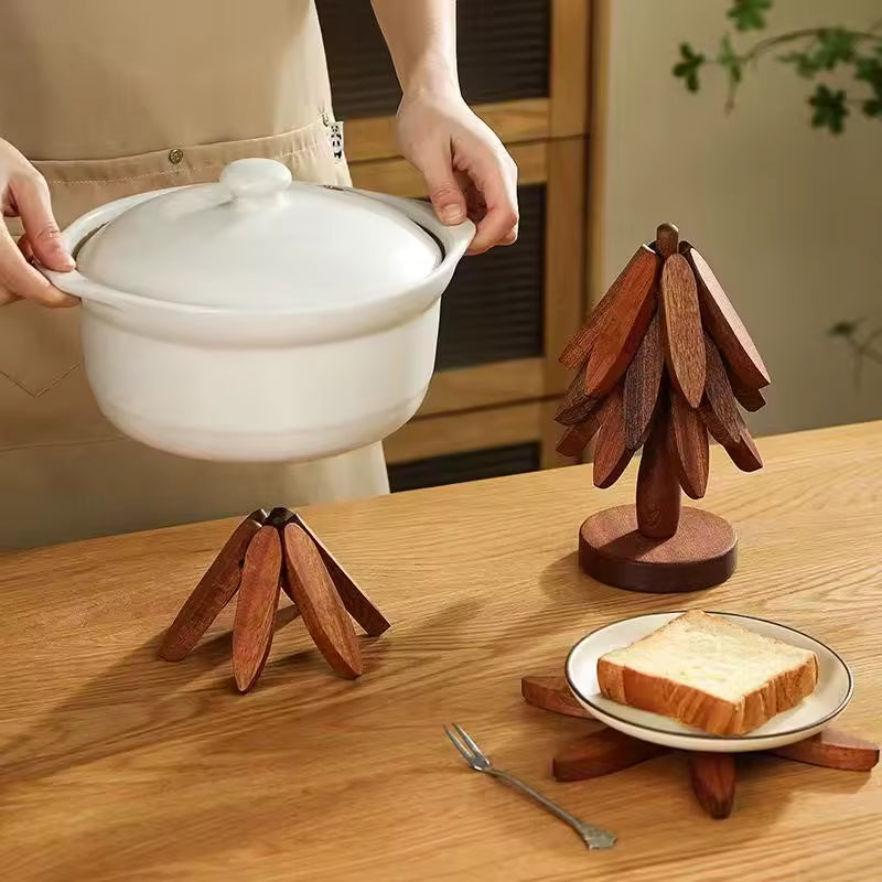 Une personne pose une cocotte blanche sur un dessous de plat en bois en forme d'étoile